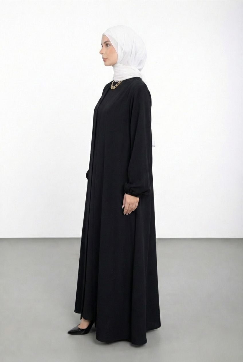 Woman wearing a black abaya and white hijab on a white background