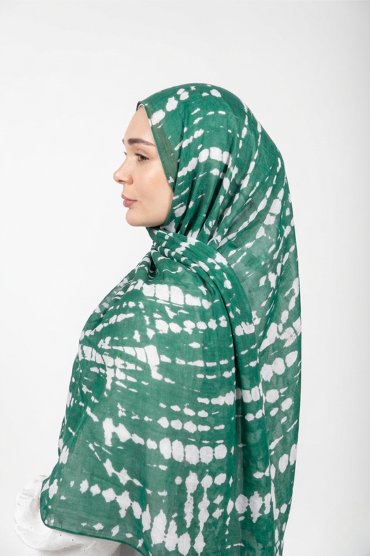 Person wearing a green and white patterned modal hijab against a white background