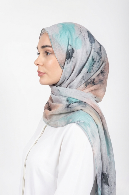 Woman wearing a patterned hijab on a white background