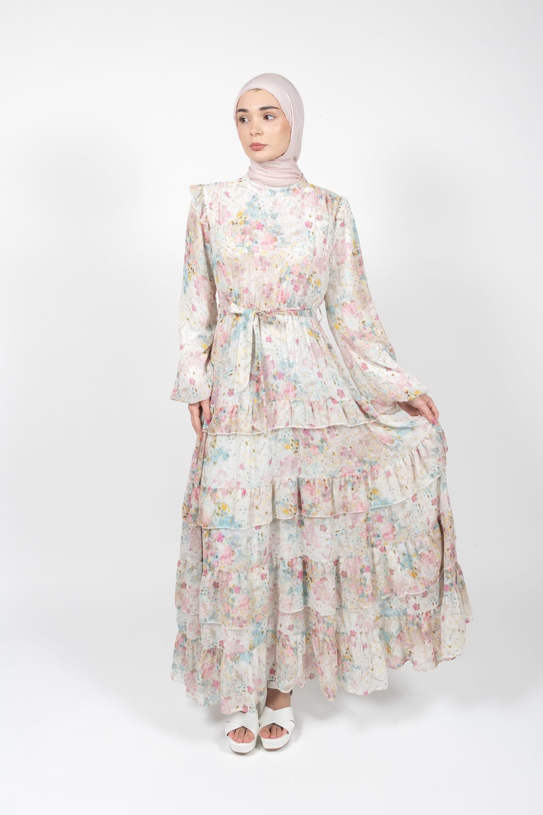 Woman wearing a floral dress with a hijab on a white background