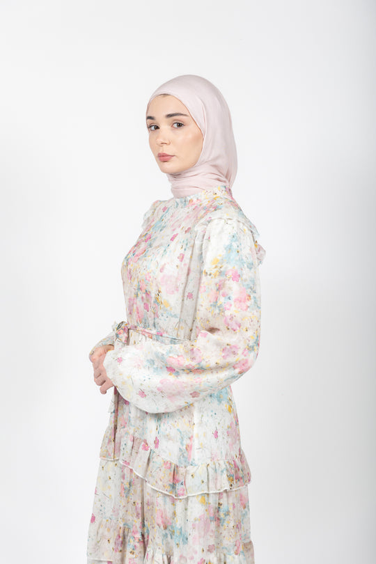 Woman wearing a floral dress and hijab on a white background