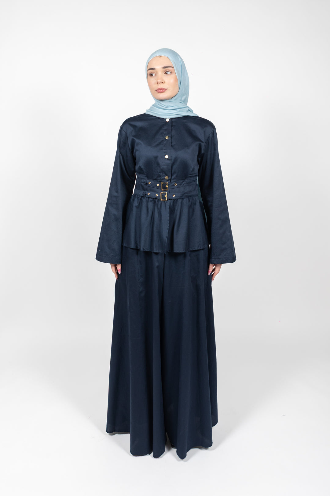 Woman wearing a navy blue outfit with a light blue hijab on a white background