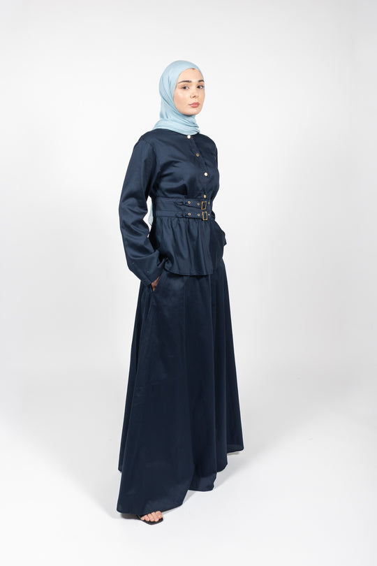 Woman wearing a navy blue outfit with a matching hijab on a white background