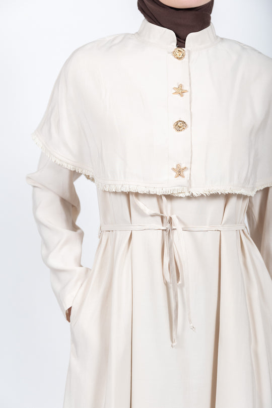 Beige dress with gold buttons on a white background