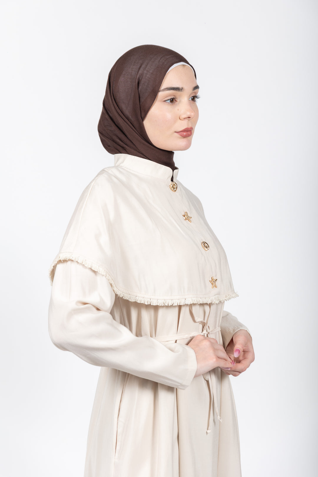 Woman wearing a white dress with a brown hijab on a white background
