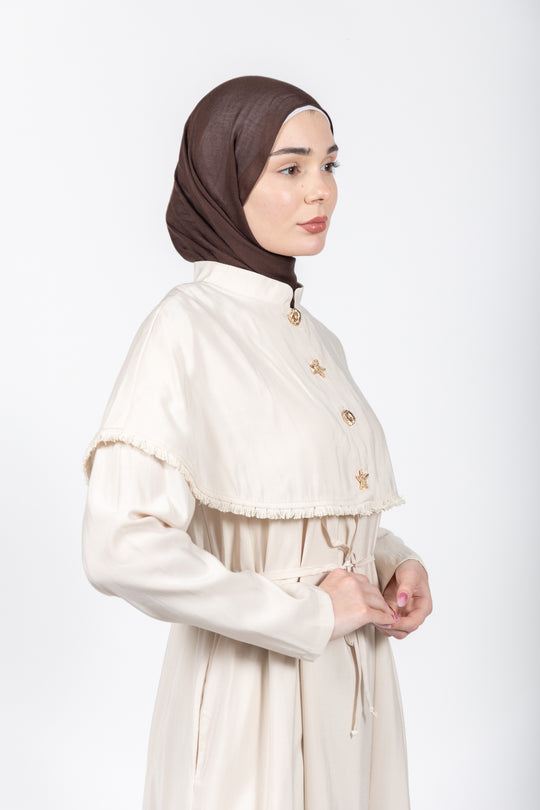 Woman wearing a white dress with a brown hijab on a white background