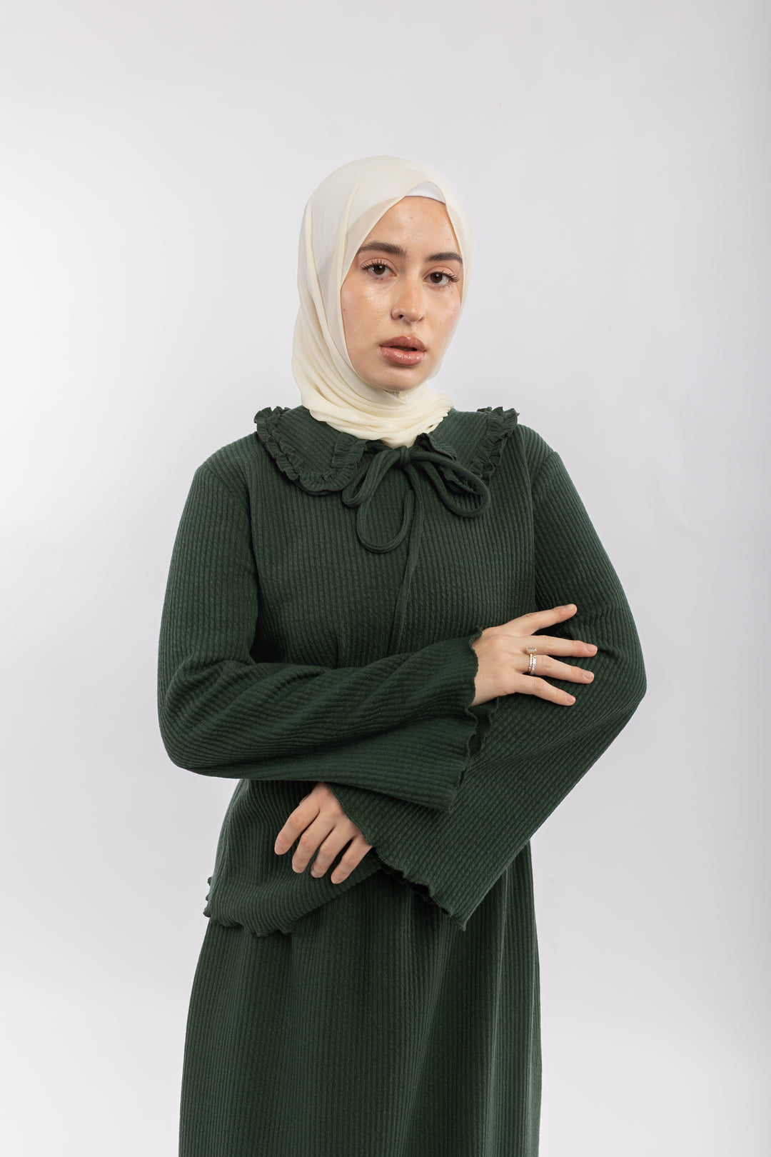 Woman wearing a green dress with a bow detail on a white background