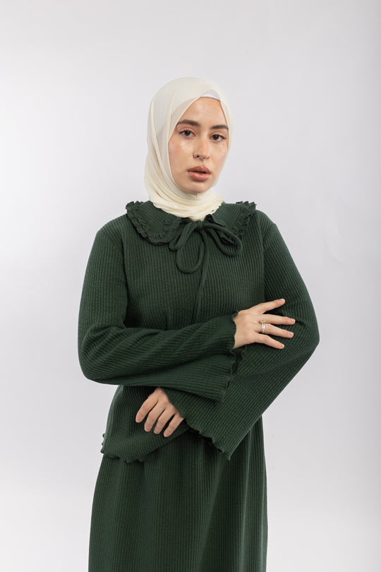 Woman wearing a green dress with a bow detail on a white background
