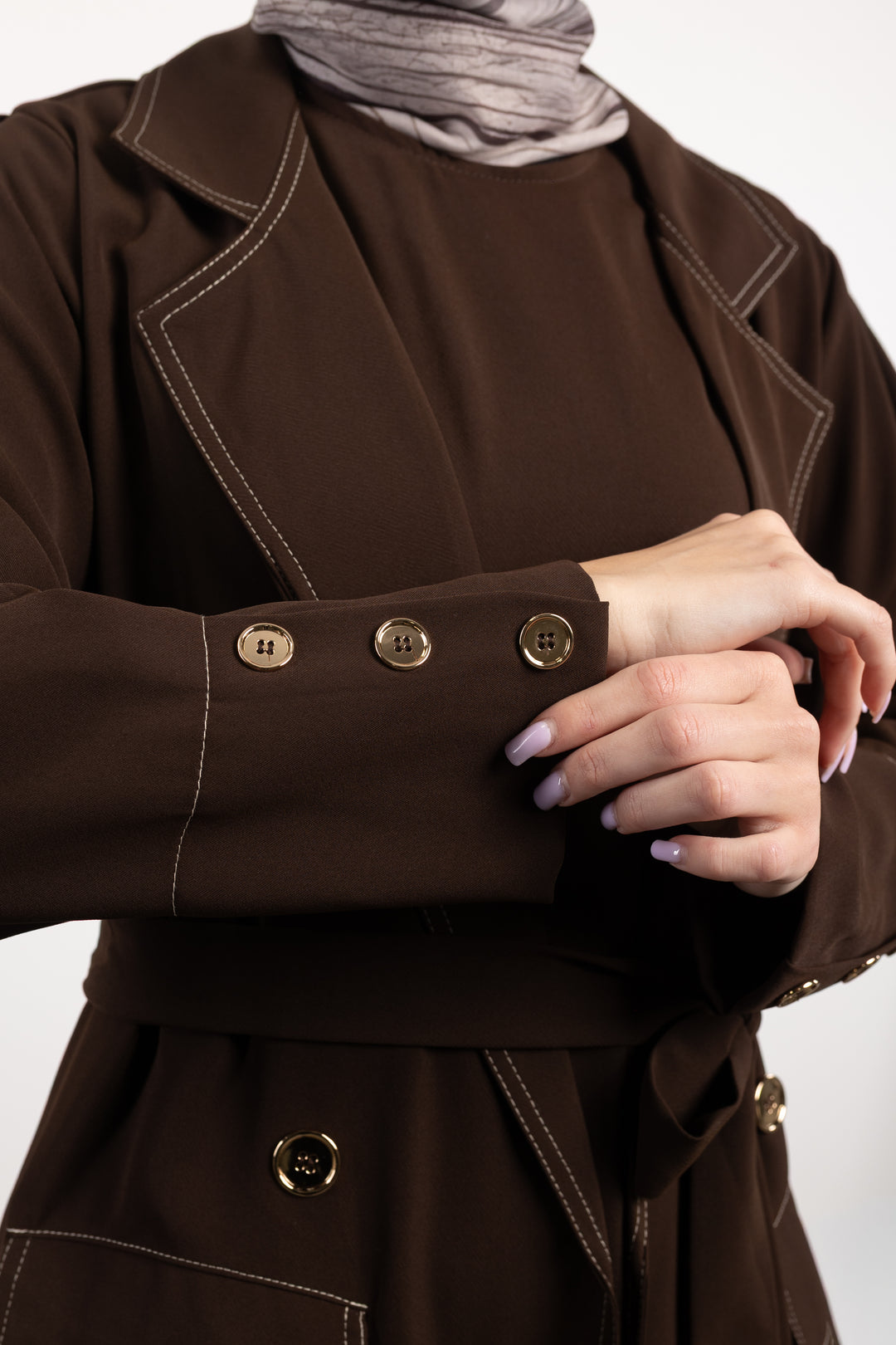 Brown coat with gold buttons on a plain background