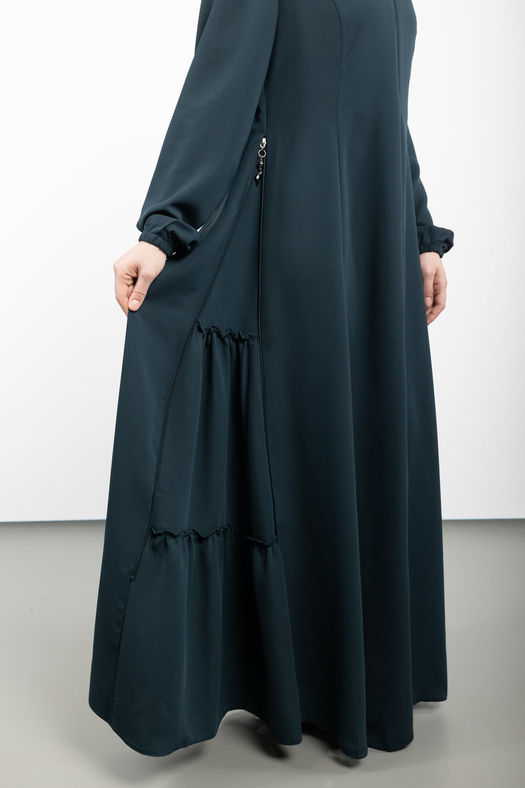 Navy blue long dress with ruffled details on a white background