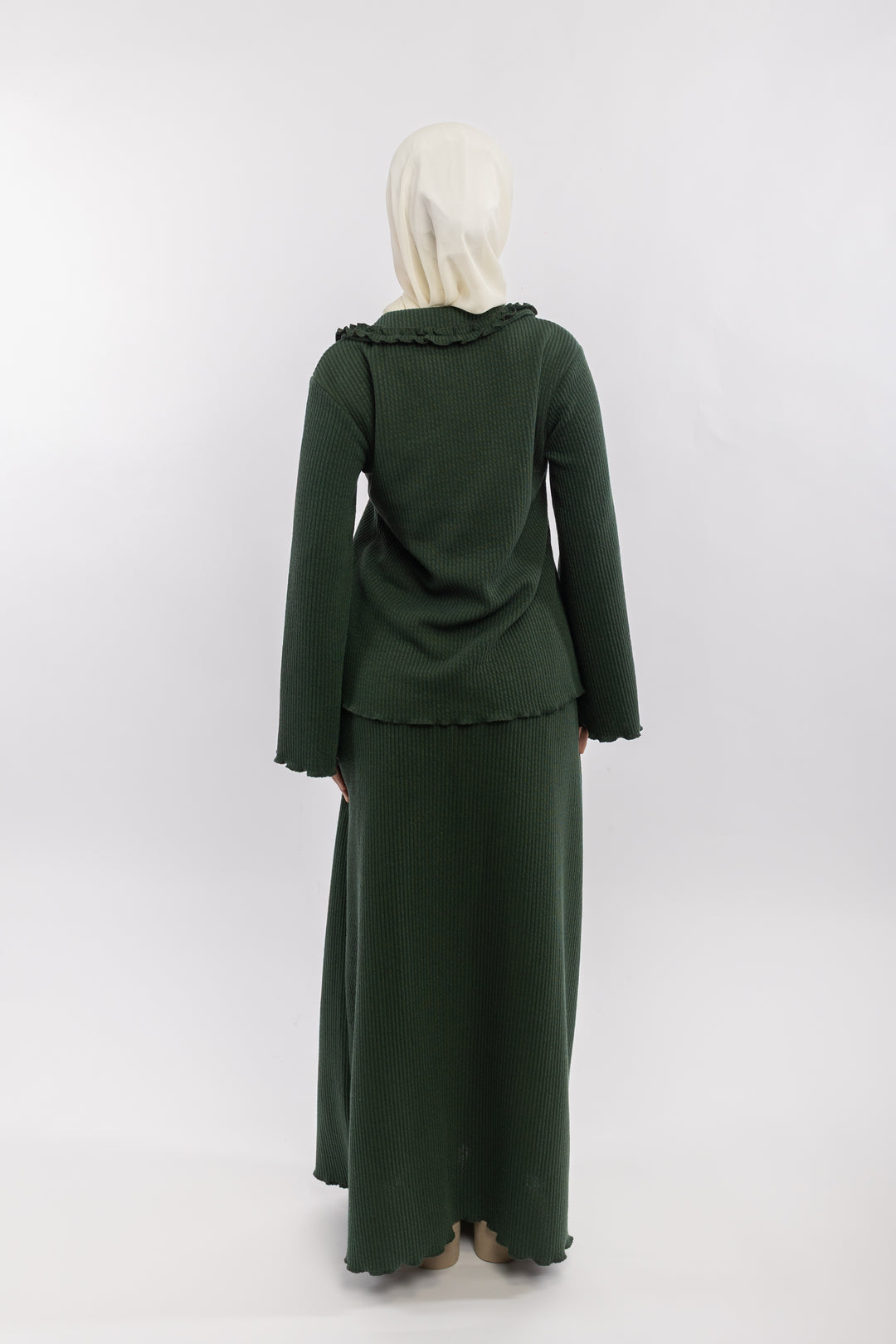 Green outfit with ruffled collar and matching skirt on a white background