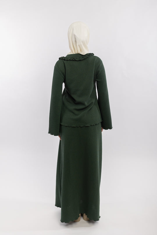 Green outfit with ruffled collar and matching skirt on a white background