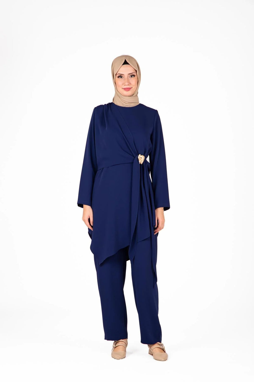 Woman wearing a navy blue outfit with a hijab on a white background