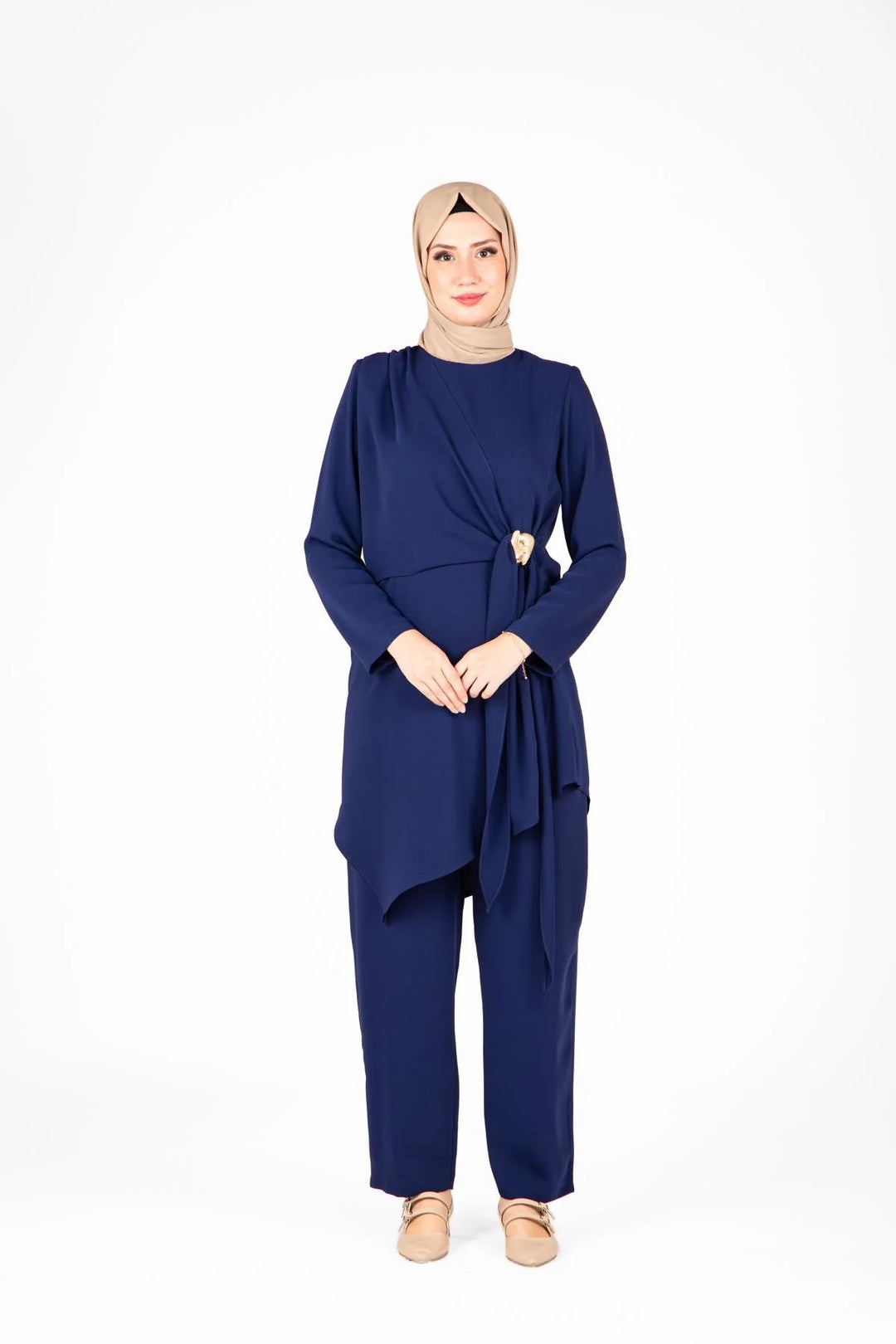 Woman wearing a navy blue outfit with a hijab on a white background