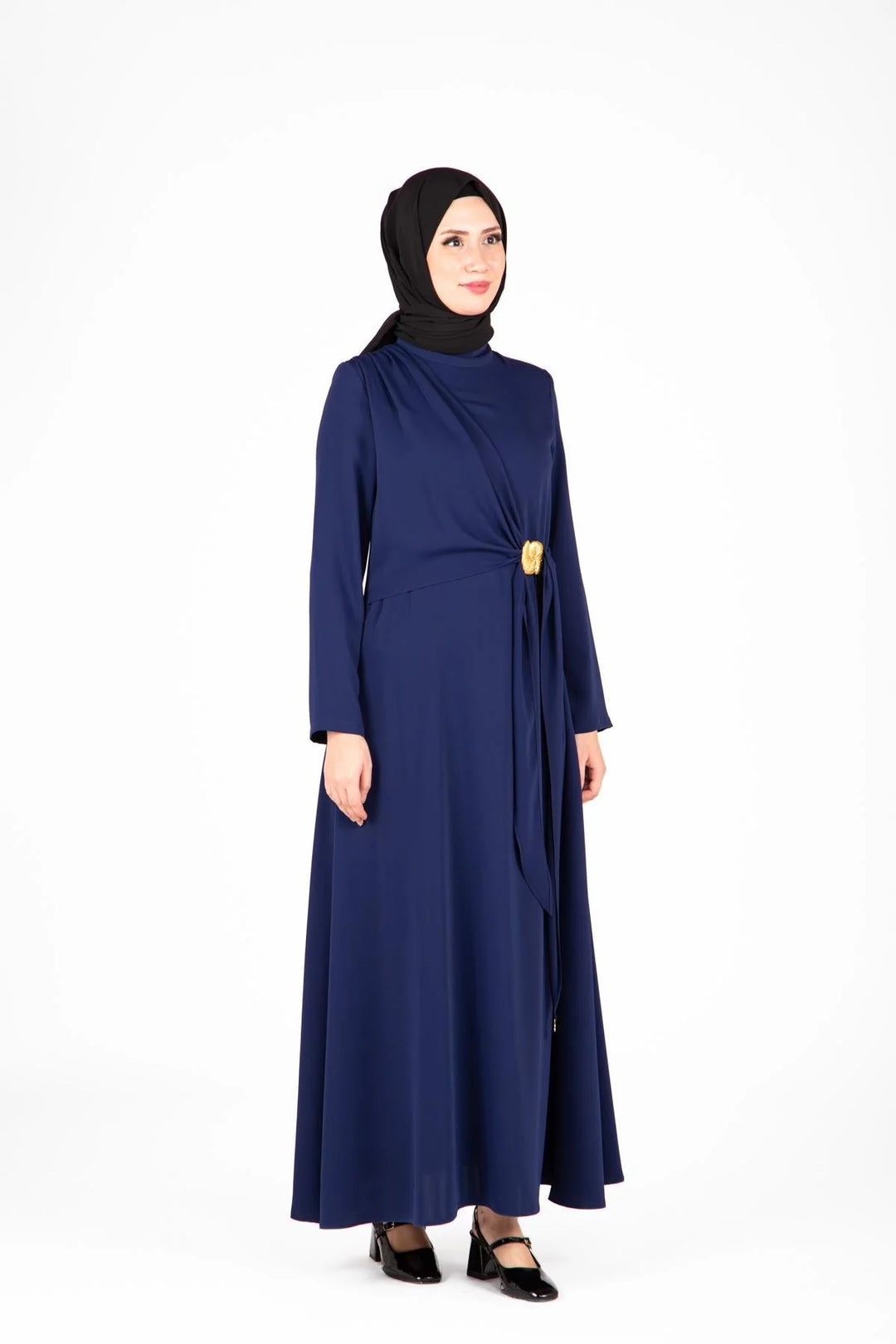 Woman wearing a navy blue abaya with a black hijab on a white background